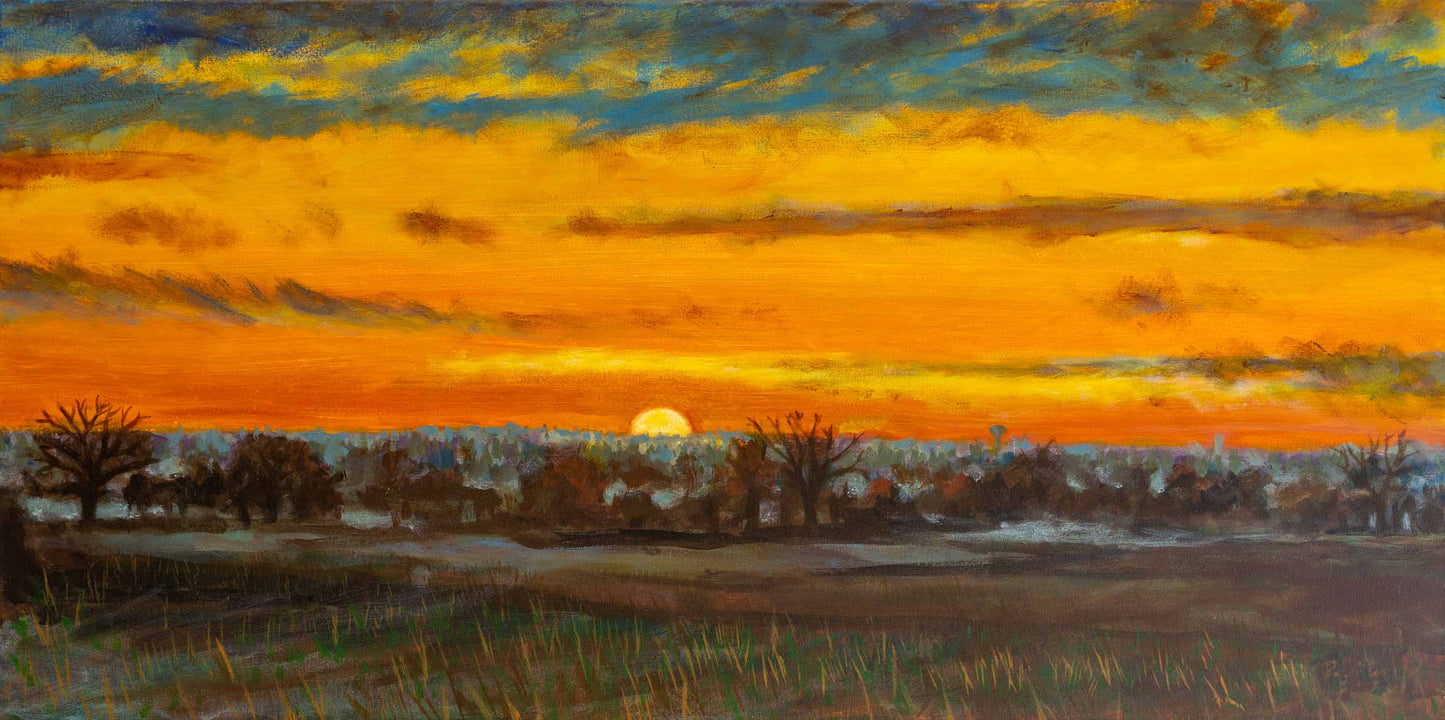A winter sunrise landscape painting depicting Barleylands in Essex. The sun rises just above the horizon, casting a vivid golden-orange glow across the sky, which transitions into cooler blue and grey tones above. In the foreground, a mist-covered farmland stretches out, its grasses softly illuminated. Bare trees and darker vegetation create silhouettes, with a distant industrial skyline faintly visible through the haze. 100 cm by 50 cm 3.8 cm deep..
